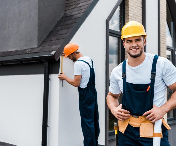 selective-focus-of-happy-handyman-in-uniform-near-service.jpg